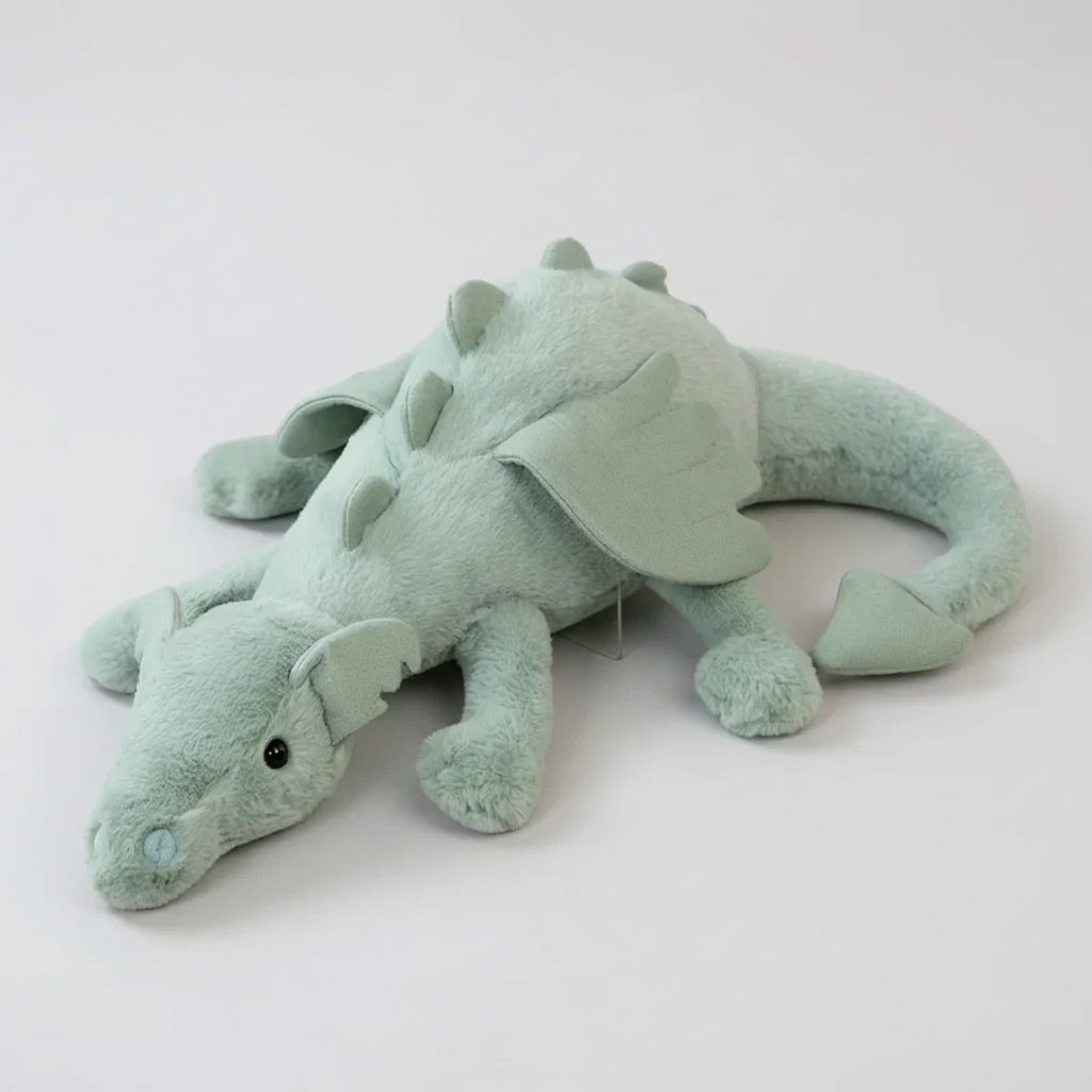 Cute green dragon plush toy with soft wings, perfect for kids' playtime. Stuffed animal for nursery decor.