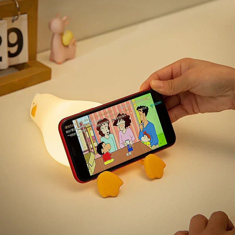QuackLite duck LED night light, soft silicone, a cute bedside lamp for kids, aiding peaceful sleep.
