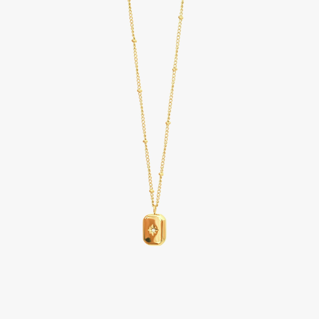 Close-up of a delicate zirconia stone pendant on a women's necklace, adding elegant sparkle.