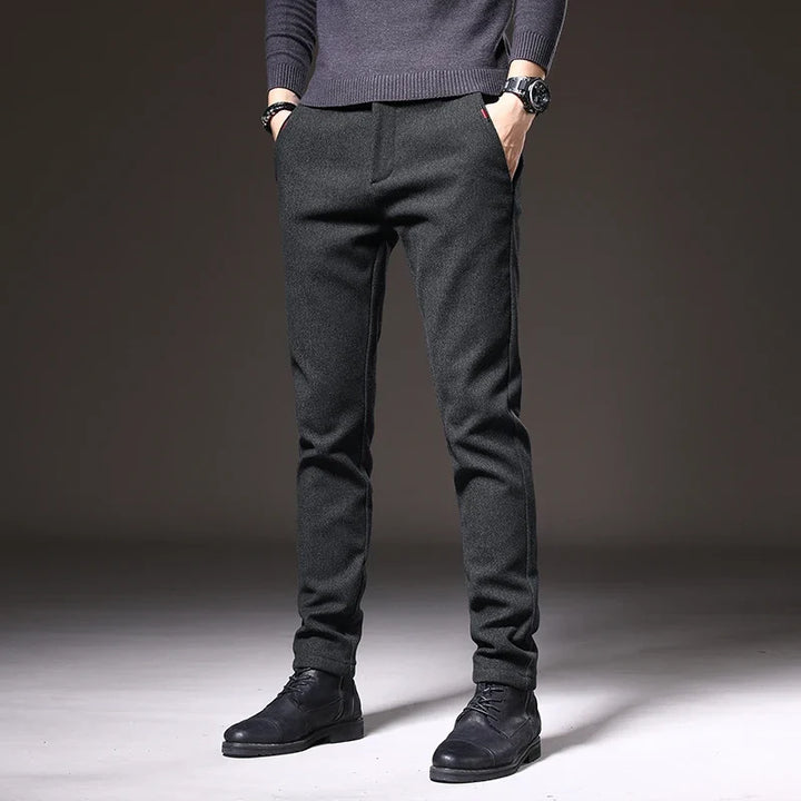 Man wearing dark gray slim fit stretch trousers, ideal for office or smart casual events.