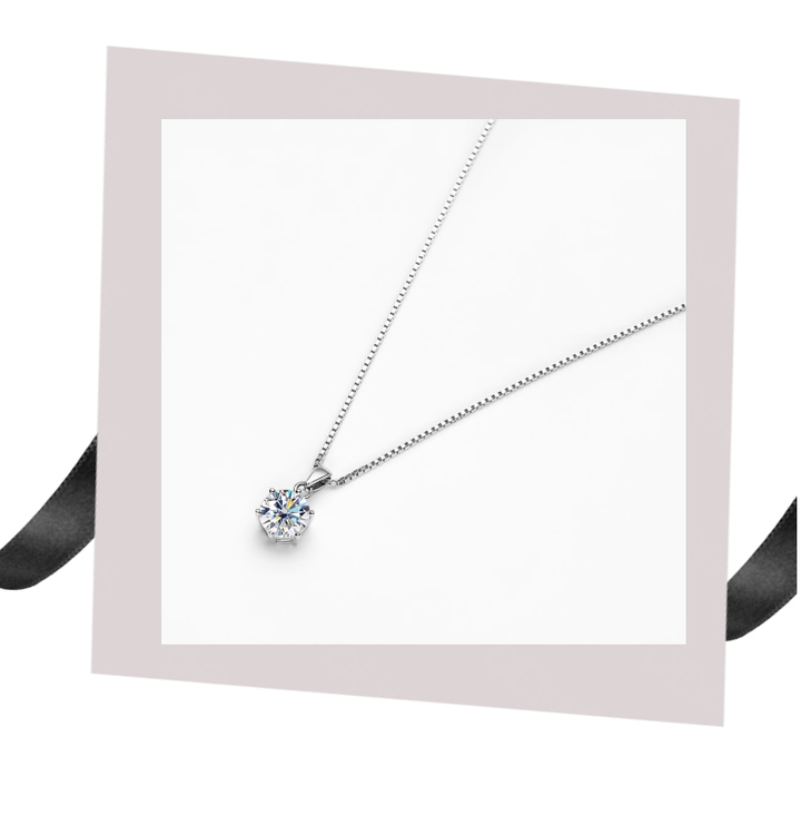 Close-up of a women's dazzling moissanite necklace, sterling silver setting, elegant fine jewelry gift.