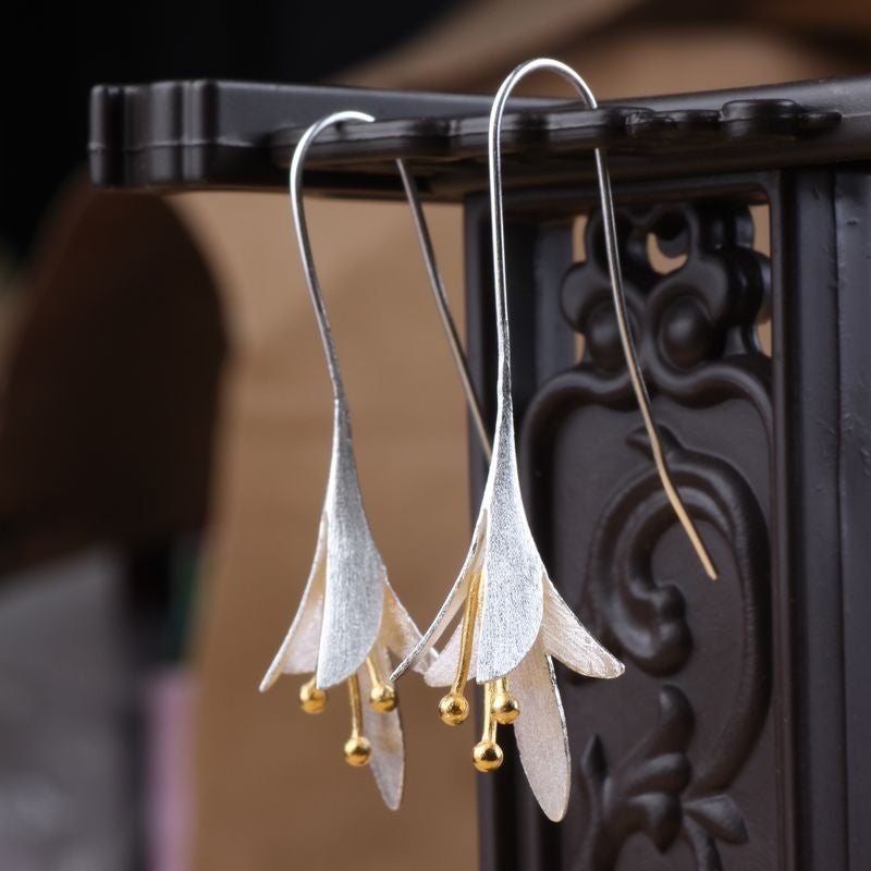 Delicate silver flower petal earrings for women, featuring an elegant floral design. Perfect jewelry accessory.