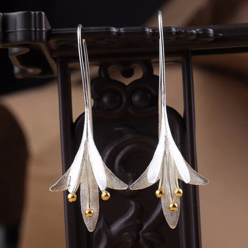 Women's elegant silver flower earrings with delicate petals. Nature-inspired floral jewelry accessory.
