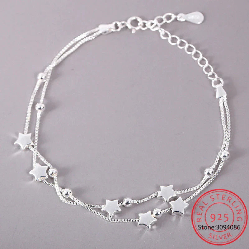 Close-up of a delicate sterling silver adjustable bracelet with a dainty star charm. Minimalist women's everyday jewelry.
