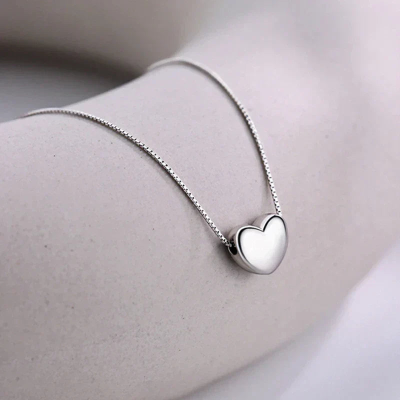 Womens sterling silver minimalist heart necklace. A delicate, smooth design makes it a versatile and elegant everyday accessory.