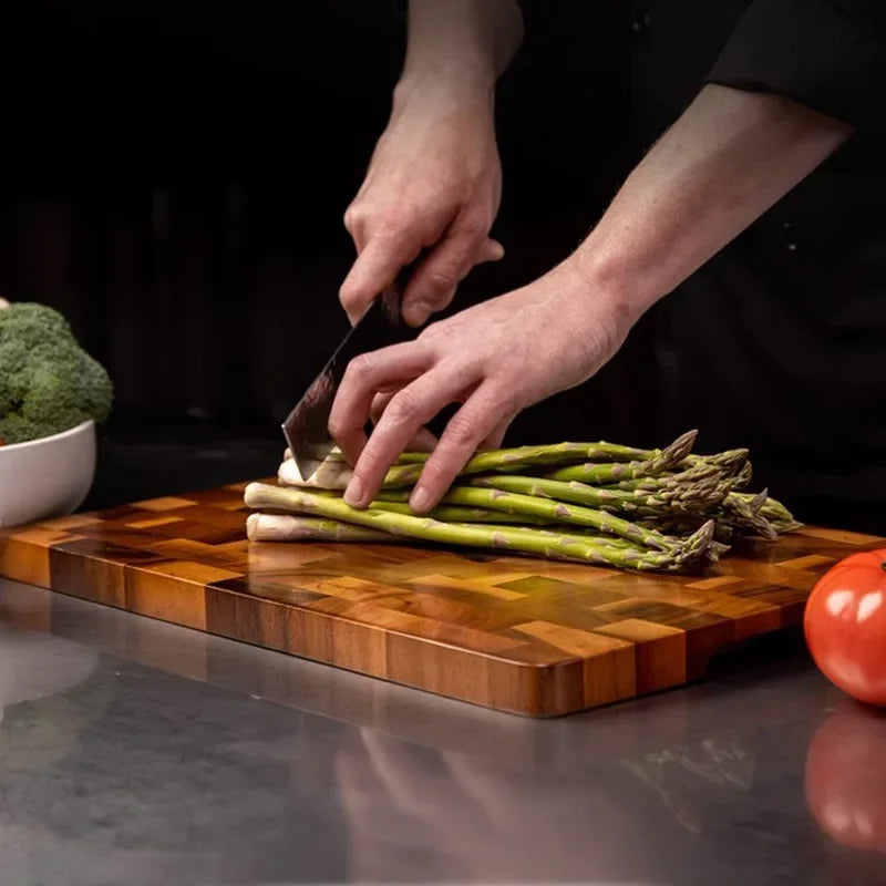 Durable double-sided acacia wood chopping board, a versatile kitchen tool for efficient food preparation and juice drainage.