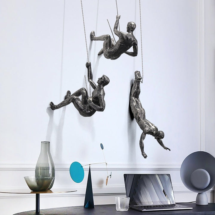 Modern wall sculpture of a climbing figure, perfect for office decoration.