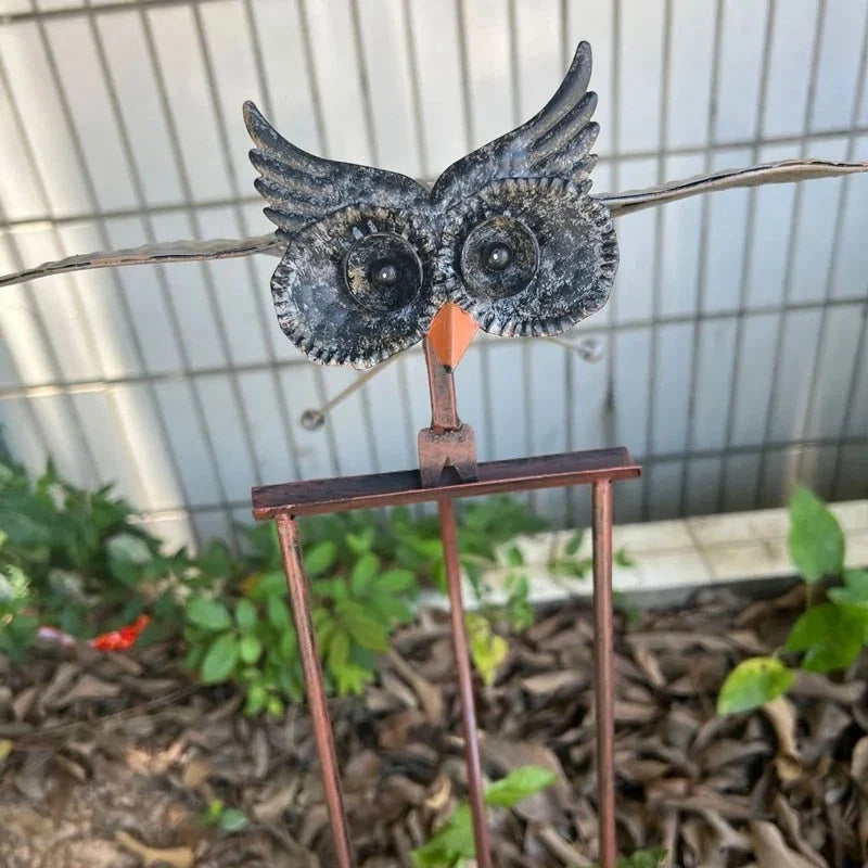 Dynamic wind spinner bird garden art, creating movement. Metal outdoor patio decor.