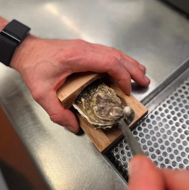 Durable wooden oyster clamp & shucking tool. Securely holds oysters for safe, efficient seafood prep.