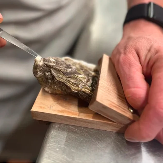 Innovative kitchen gadget: wooden oyster shucking clamp for effortless and safe seafood preparation.