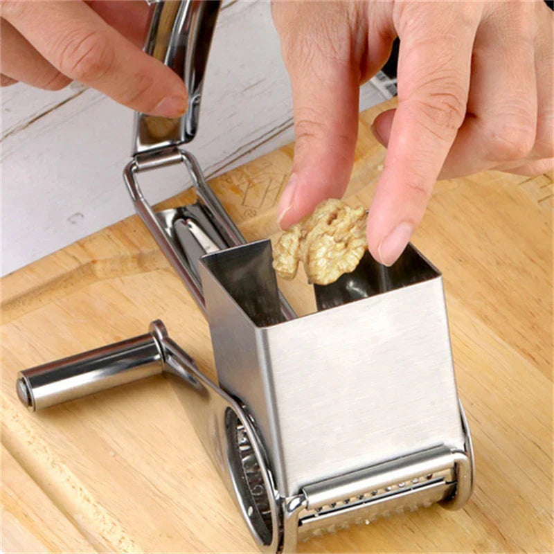 Ergonomic manual rotary grater, stainless steel, with comfortable handle for easy food prep.