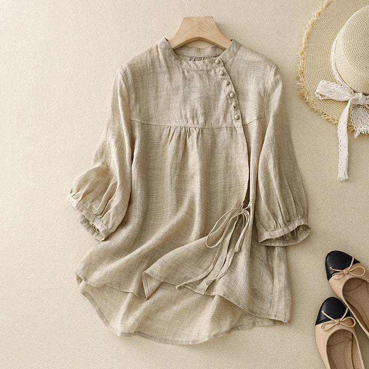 Front view of an elegant women's blouse with a flattering tie-waist and trendy puffed sleeves for any occasion.