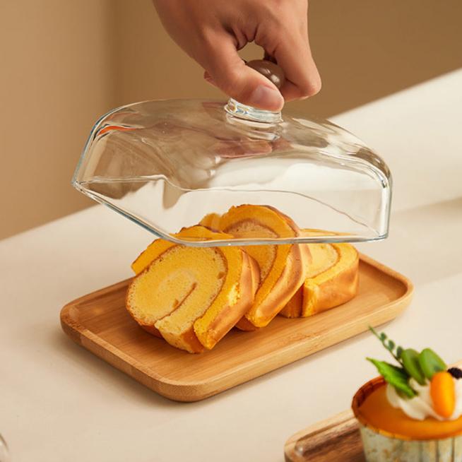 Elegant Acacia wood butter dish with clear glass lid, perfect for kitchen counter storage and serving.