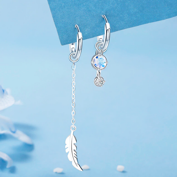Elegant asymmetric feather moonstone earrings. Sterling silver drop design for women.