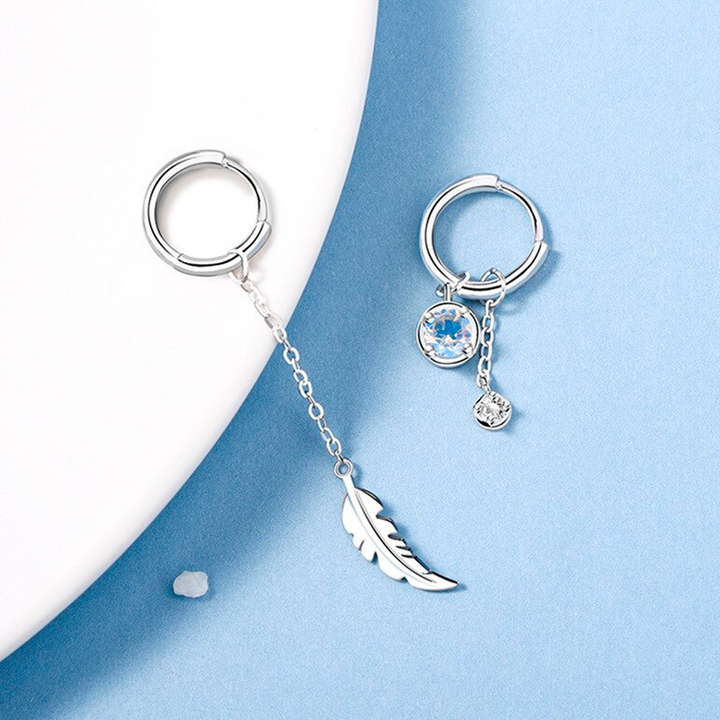 Beautiful asymmetric feather earrings with shimmering moonstone. Sterling silver, elegant women's dangle style.