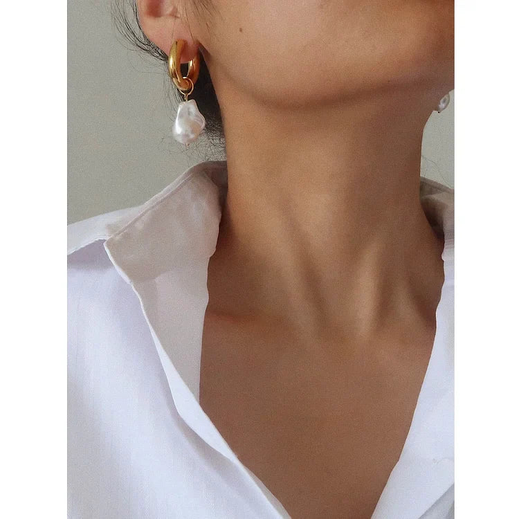 Close-up of a stunning baroque pearl drop earring for women, featuring a gold setting & natural luster.