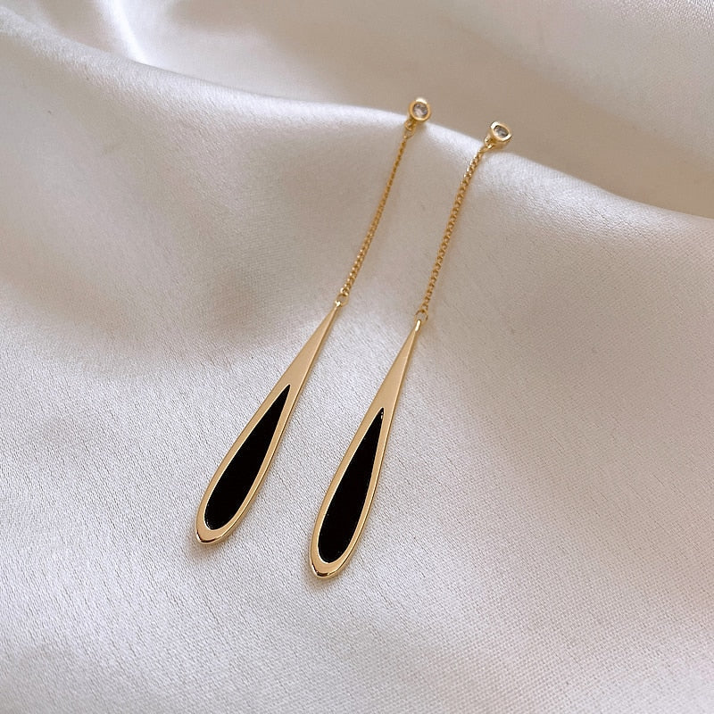 Close-up of elegant black drop earrings, showcasing sleek design, ideal for women's fashion jewelry.