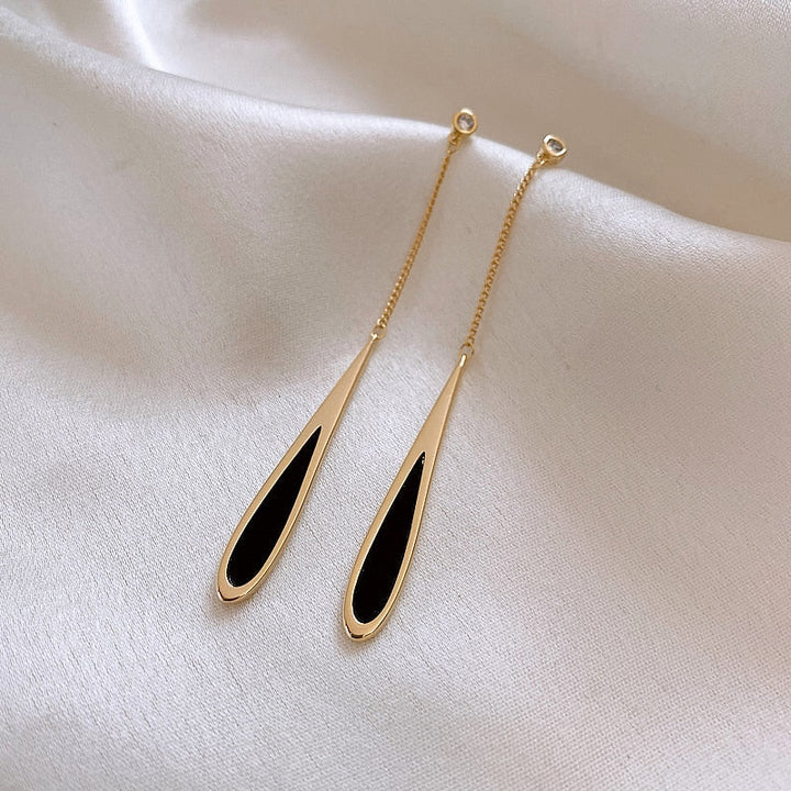 Close-up of elegant black drop earrings, showcasing sleek design, ideal for women's fashion jewelry.