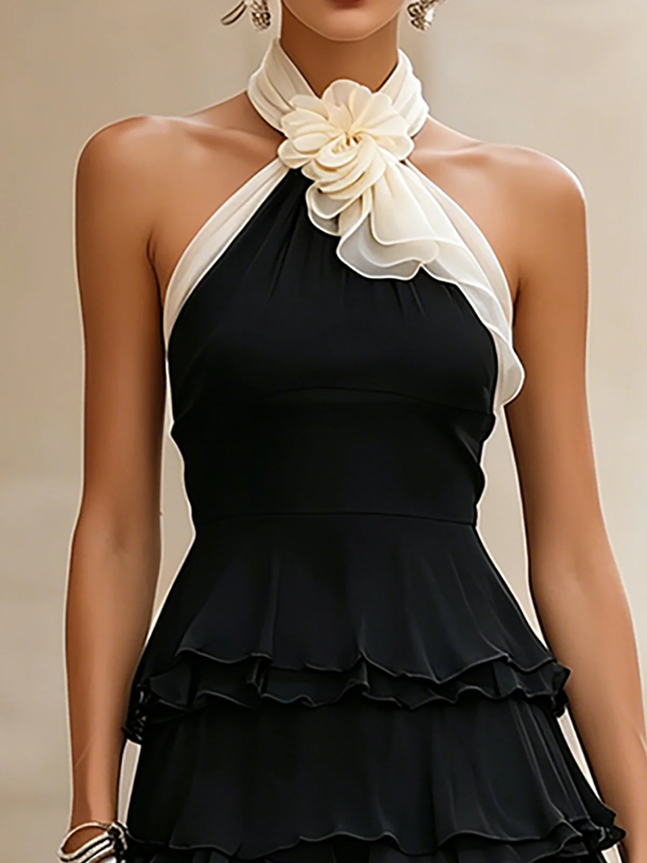 Chic women's black tiered ruffle mini dress, featuring a halter neckline and delicate rosette accents.