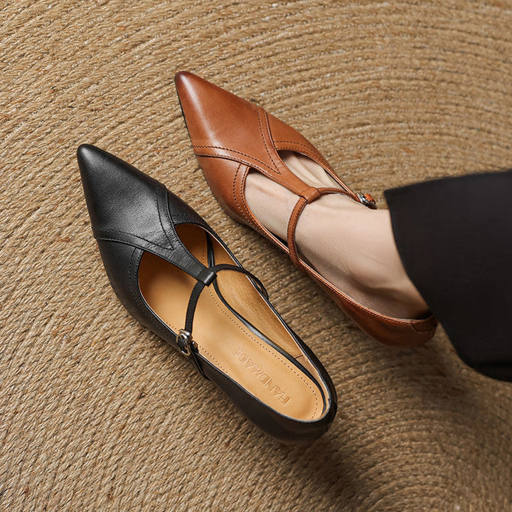 Top view of chic black T-strap mid-heel shoes, highlighting the refined strap details.