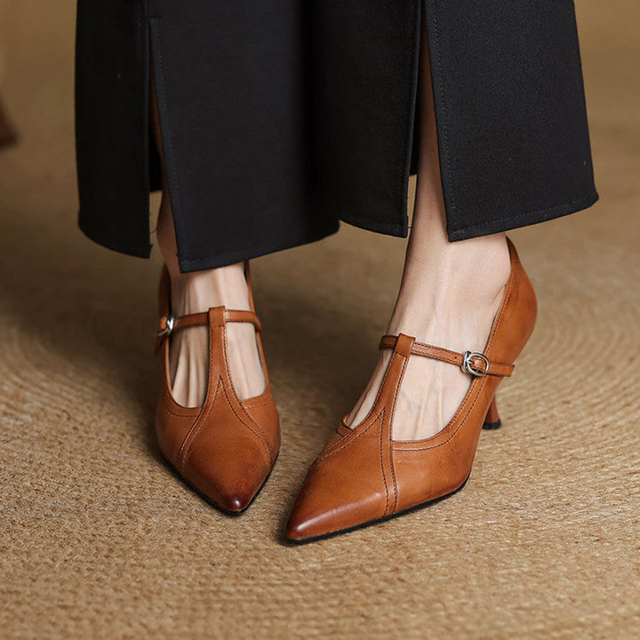 Chic brown T-strap mid-heel shoes with a delicate buckle, ideal for dressy occasions.