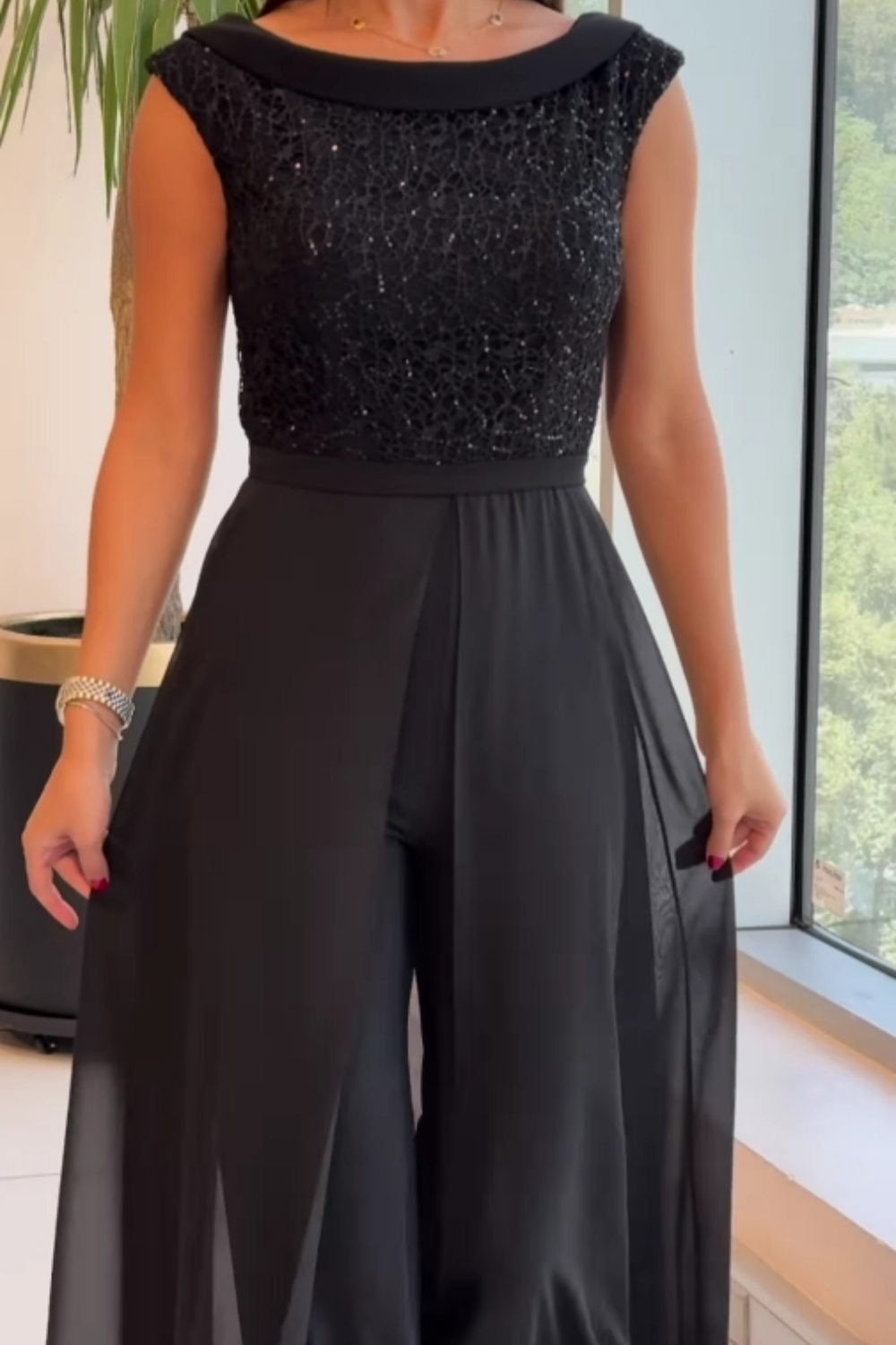 Sleek black textured crew neck jumpsuit for women, a modern and chic one-piece for any occasion.