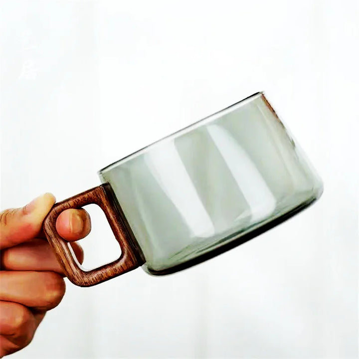 Modern glass mug with a natural cedar wood handle, excellent for home decor and beverage serving.