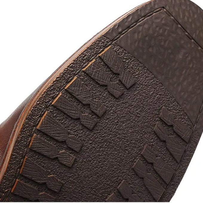 Side view of men's black Chelsea boots, showcasing elastic gusset & sleek design. Versatile for dress or casual outfits.