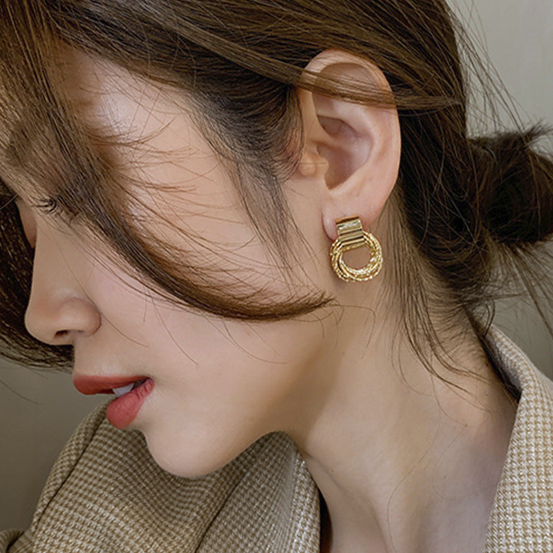 Shiny gold-tone circle stud earrings. Elegant women's jewelry, minimalist design, versatile fashion.