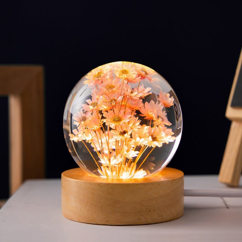 Decorative crystal ball lamp with embedded eternal flowers, providing warm ambient light for any room.