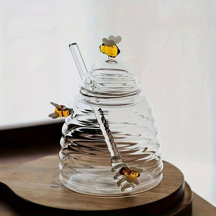 Borosilicate glass honey jar with dipper, elegant beehive design, ideal for serving honey or syrup.