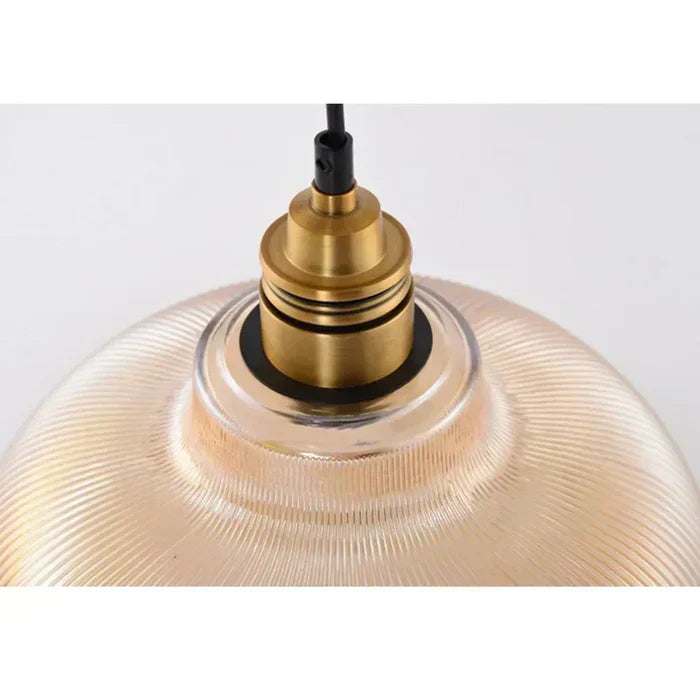 Warm glow from a glass pendant light. Elegant indoor lamp, ideal ceiling fixture for cozy bedroom lighting.