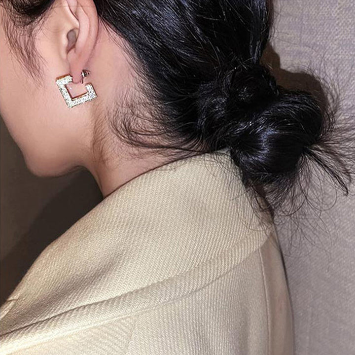 Royal Chimes gold dangle earrings, a chic hypoallergenic accessory for women with sensitive skin.