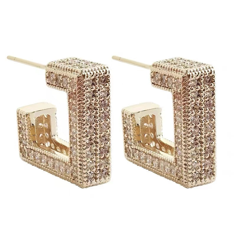 Sparkling gold dangle earrings, hypoallergenic for women with sensitive skin. Elegant and delicate accessory.