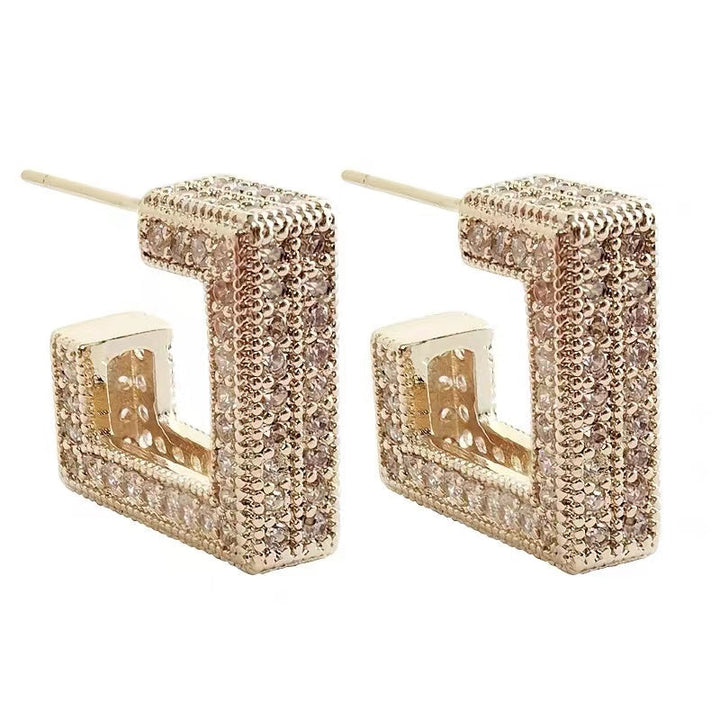 Sparkling gold dangle earrings, hypoallergenic for women with sensitive skin. Elegant and delicate accessory.