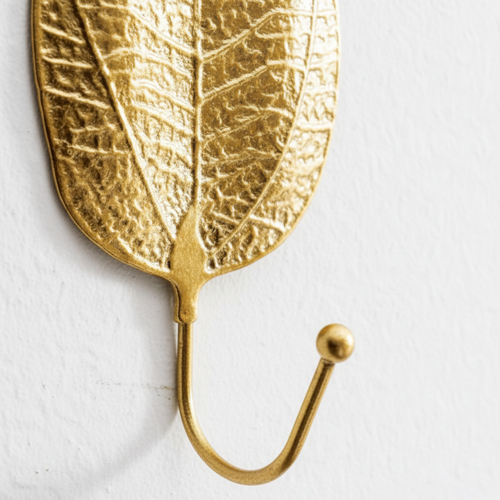 Golden cast iron Leafora wall hook with a nature-inspired leaf design, ideal for adding a touch of elegance to any room.