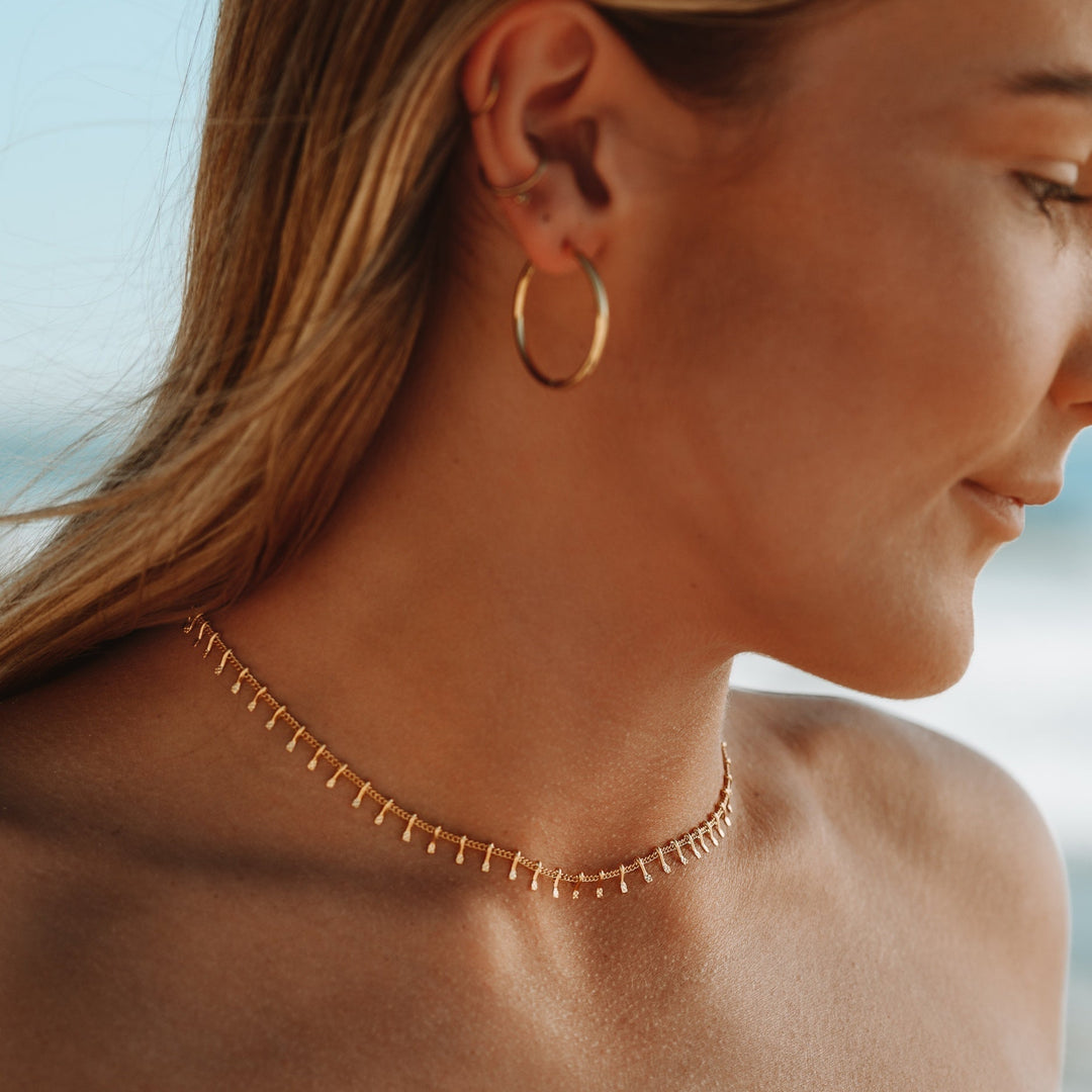 Close-up of a delicate gold minimalist choker necklace. Sophisticated jewelry for women's elegant style.
