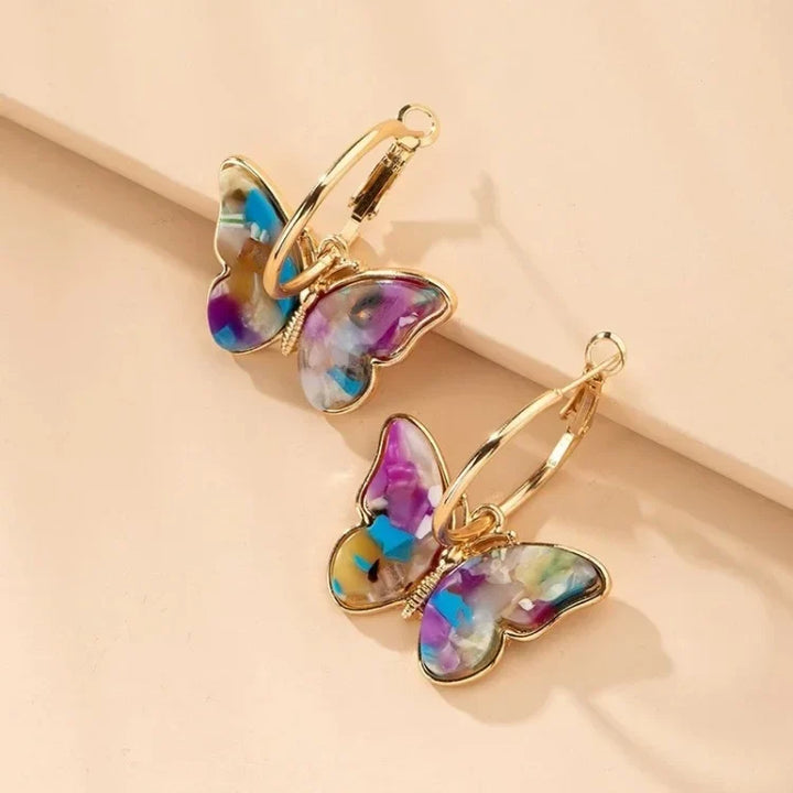 Gold plated butterfly earrings for women, adorned with clear acrylic crystals. Hypoallergenic and fashionable jewelry accessory.
