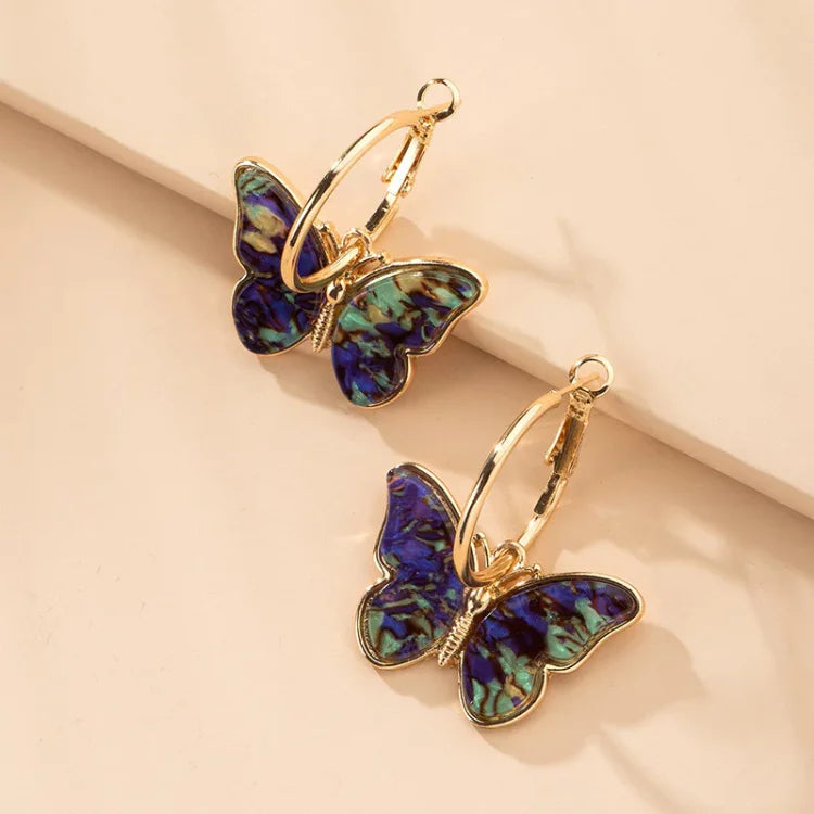 Delicate gold plated butterfly earrings featuring shimmering acrylic crystals. Stylish women's jewelry, an elegant statement piece.