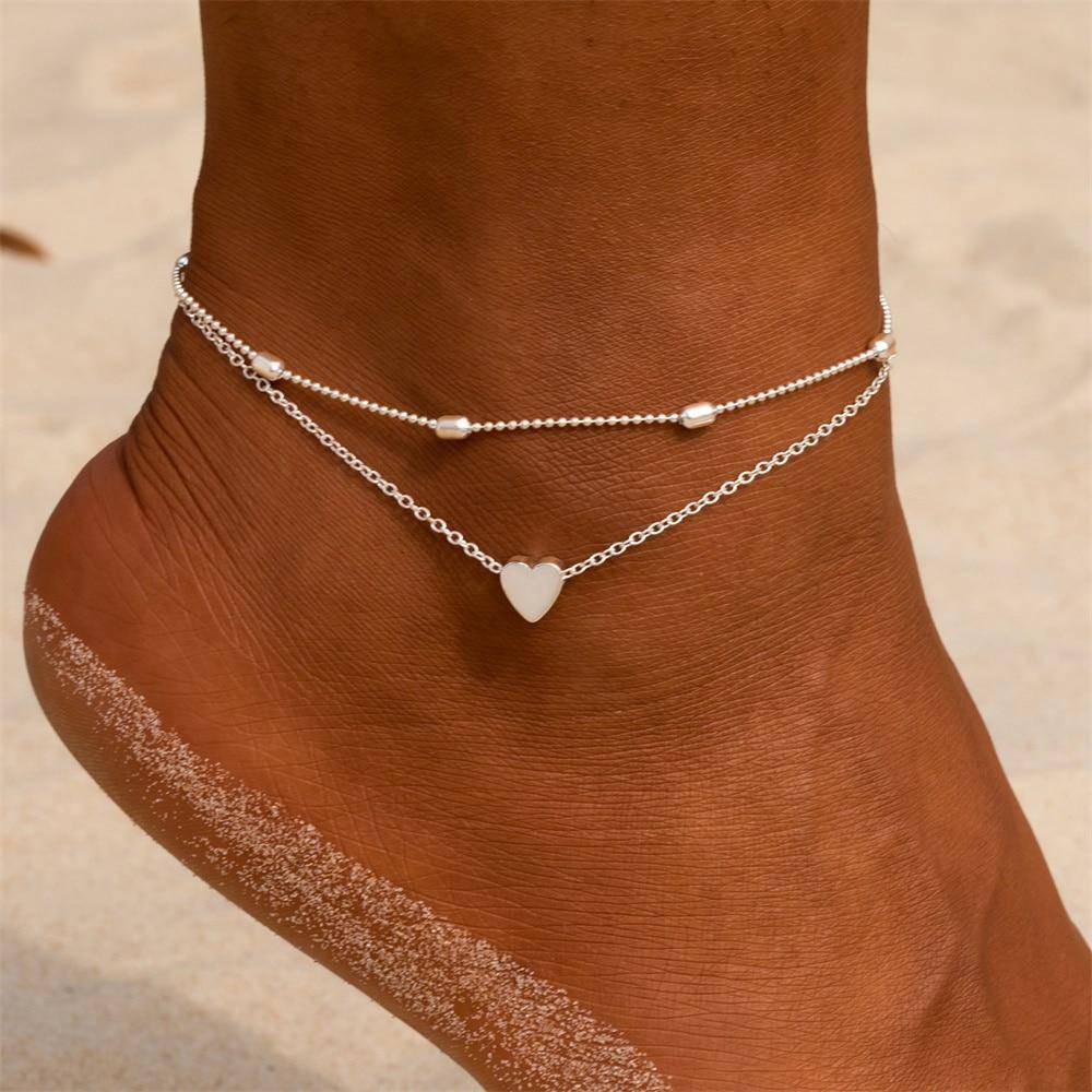 Elegant gold-plated double chain anklet with delicate heart charm for women. Adjustable fashion accessory.