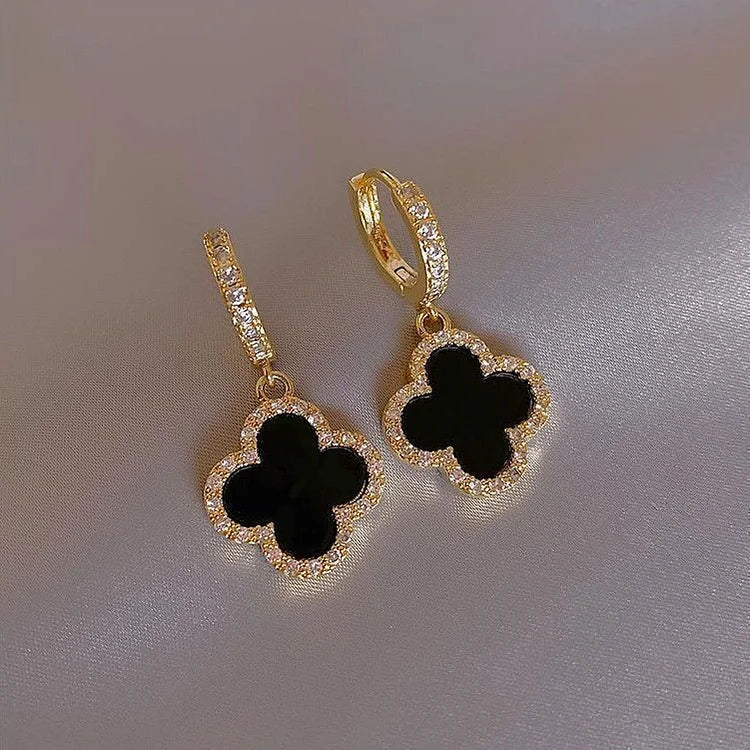 Stylish gold plated women's drop earrings featuring delicate four leaf clovers, a chic fashion accessory.