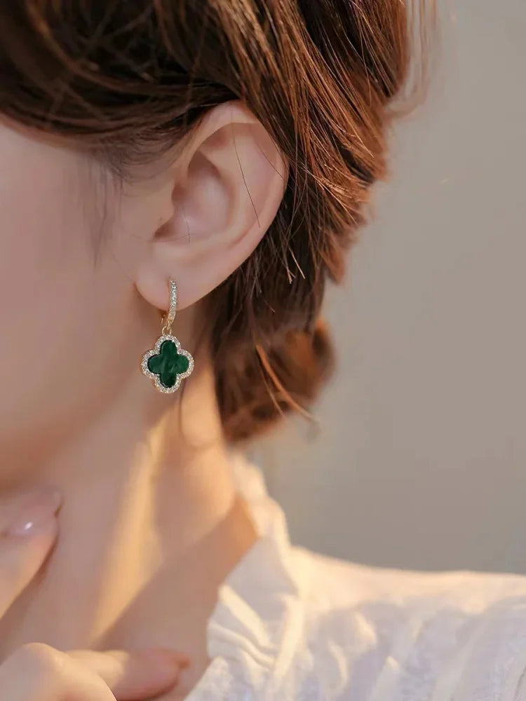 Delicate four leaf clover drop earrings for women, gold plated and perfect as a lucky everyday wear accessory.