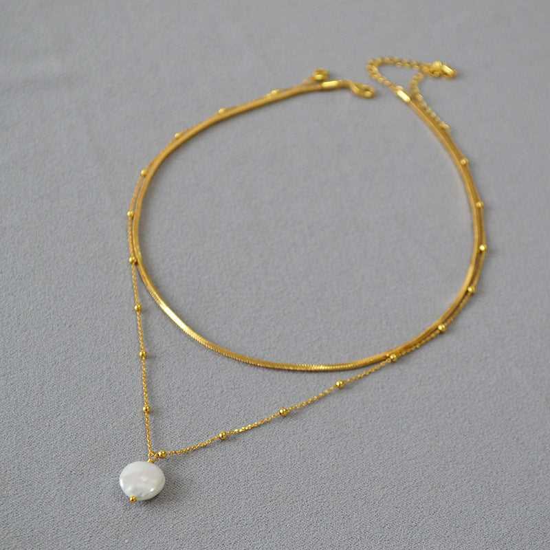 Elegant gold-plated women's layered necklace featuring unique baroque pearls and sterling silver accents.