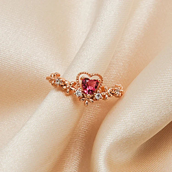 Close-up of a women's gold-plated red crystal love ring with sparkling AAA Zirconia, perfect elegant jewelry.