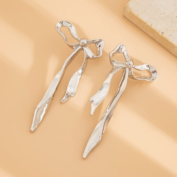 Beautiful gold ribbon bow earrings. Elegant and dainty women's accessory, perfect fashion statement.