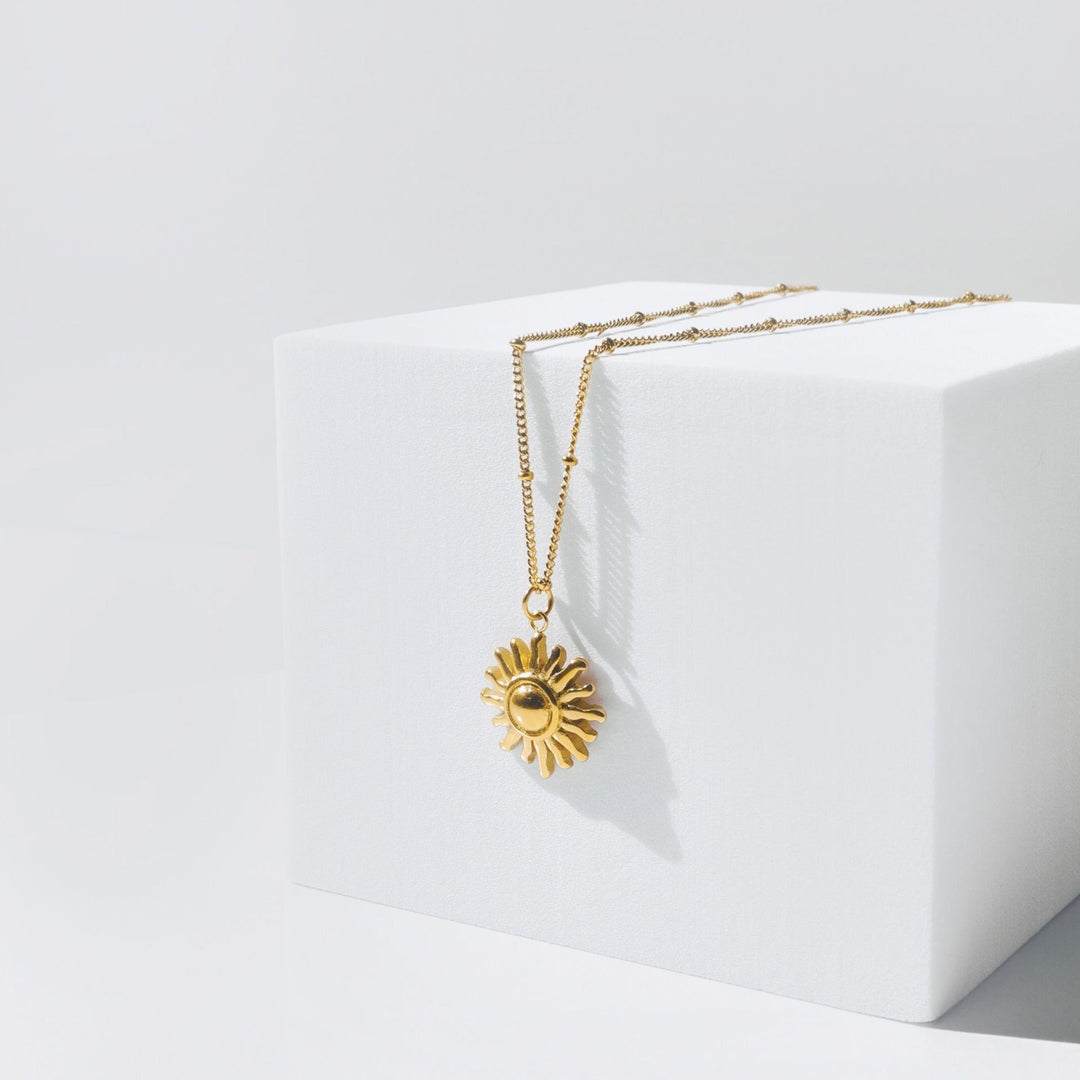 Elegant gold sun pendant necklace for women, a stylish fashion jewelry piece. Perfect gift idea for her.
