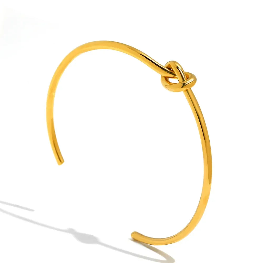Stylish women's gold twisted knot bangle, featuring a unique intricate design.