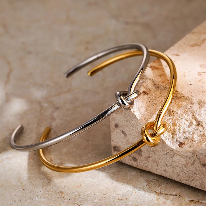 Shiny gold twisted knot bangle bracelet for women, offering a modern and chic jewelry statement.