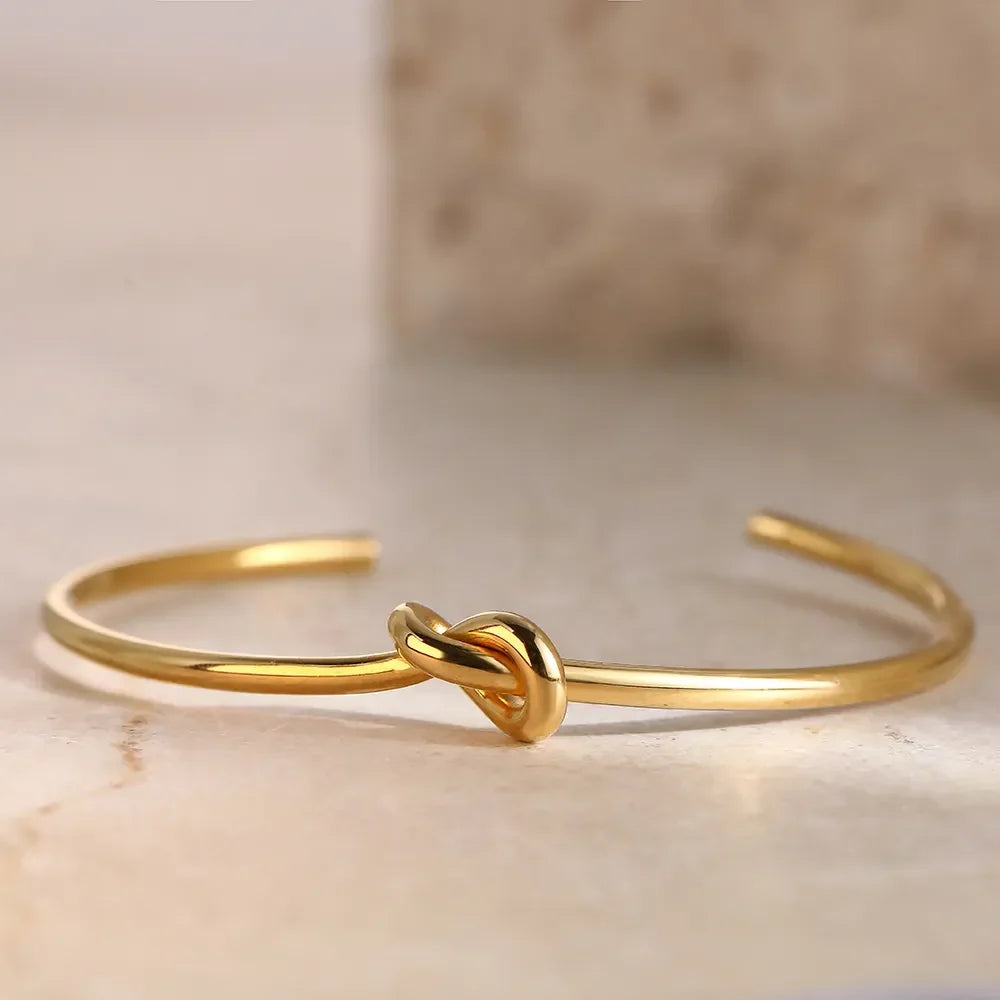 Adjustable gold twisted knot cuff bangle, a classic women's jewelry piece with elegant appeal.
