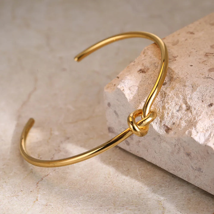 Delicate gold twisted knot bracelet, a timeless women's accessory adding elegance to any outfit.